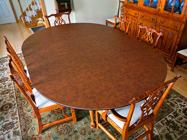 Dining table enlarged using rounded table extender pad